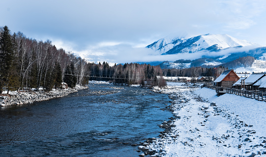 snow mountain river and village at dusk