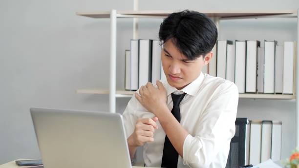 istock Exhausted young asian male worker suffer from strain muscles, neck pain while working on laptop at office. Tired stressed man having neck pain. Office Syndrome concept 1496910243
