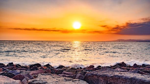 istock Vibrant sunset sky glows over a picturesque rocky beach 1496911613