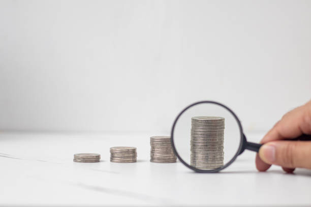 istock Coins placed high up against a magnifying glass to make them look bigger. 1496911655