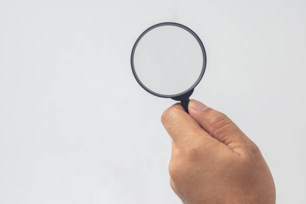 istock hand holding a magnifying glass on a white background 1496911671