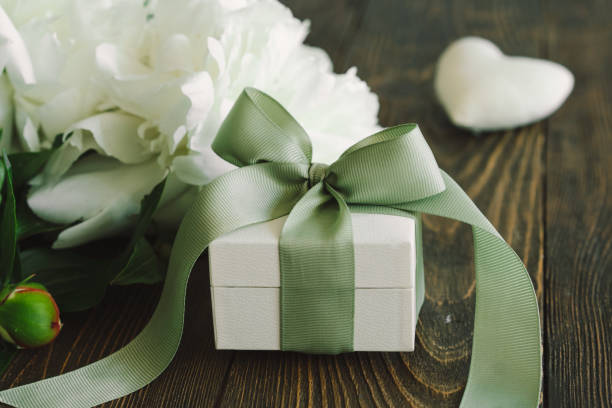Bouquet of beautiful white peonies with gift boxes Bouquet of beautiful white peonies with gift boxes on wood background. Stylish floral greetings. Mothers day birthday present stock pictures, royalty-free photos & images