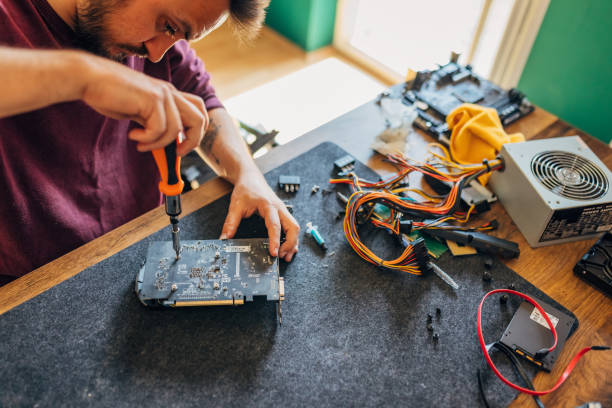 istock Concentrated man uses a screwdriver to remove the cooler to clean the graphics card processor 1496914137