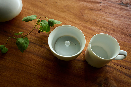 Cup of aromatic black tea with fresh mint and dry leaves on wooden table, flat lay. Space for text