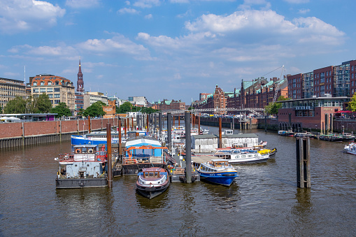 Hamburg, Germany - July 25, 2012: old brick speicherstadt in Hamburg harbor with pier of ship in foreground. Speicherstadt is a  Unesco world heritage site.