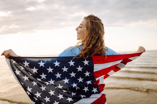 istock Young woman with American flag on the beach. 1496920762