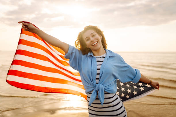istock Young woman with American flag on the beach. 1496920838