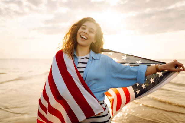 istock Young woman with American flag on the beach. 1496920843
