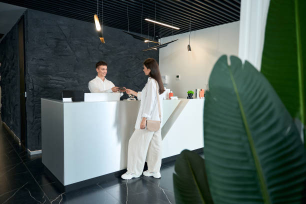 istock Young man offering amenities brochure to female 1496925567