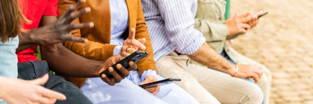 istock Multiracial friends watching smartphone – multicultural young people looking mobile phone - horizontal web banner size for header 1496927584
