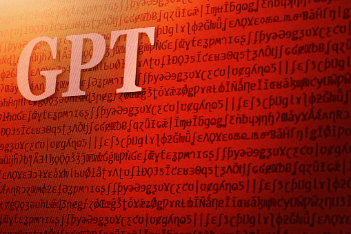 Photograph of a computer screen displaying the abbreviation GPT. The backdrop of meaningless special characters symbolizes the \