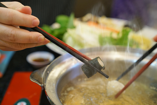 chopsticks holding meat ball in restaurant