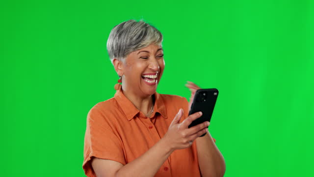 Senior woman, phone and laughing on green screen for funny meme, joke or social media against studio background. Happy elderly female laugh on mobile smartphone for fun chat or online post on mockup