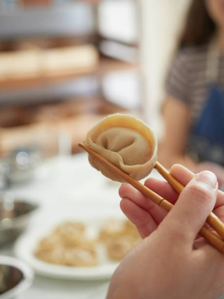 istock Homemade dumpling holding with chopsticks, close-up view 1496936884
