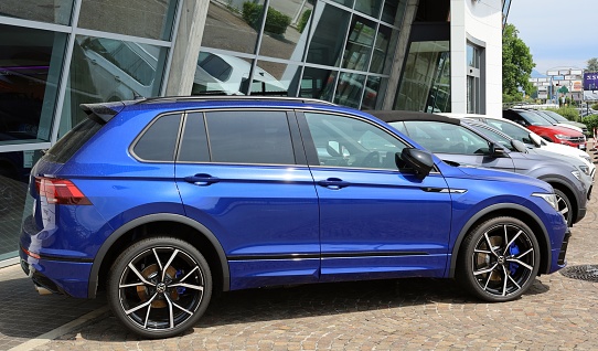 Udine, Italy. June 4, 2023. Blue Volkswagen Tiguan R, compact crossover suv of the german automaker, on display outside the official dealership. Side view.