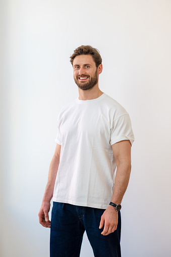 Portrait of a man standing looking at the camera with a smile while at a studio in the North East of England.