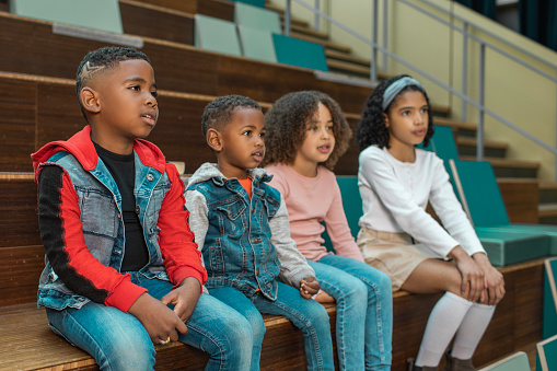 A group of young black and diverse school children in a library