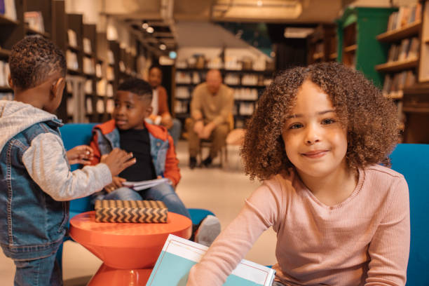 istock Portrait of a young school child black reader in a library 1496939618
