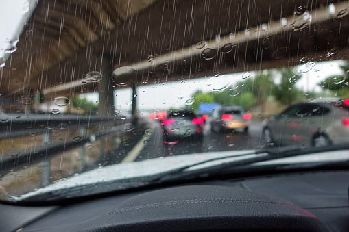 Rain that falls heavily on cars driving on the highway in the direction of the city
