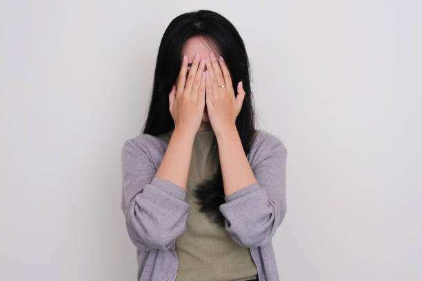 istock Young Asian women covering her face with both hands showing scared expression 1496944074