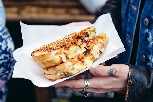 Close view of young adult holding toasted street food.