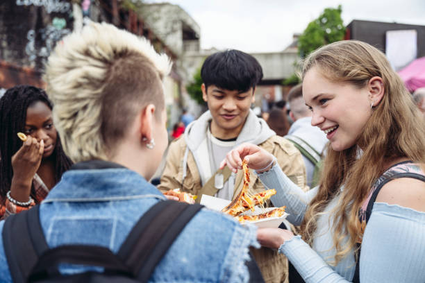 Gen Z friends standing outdoors eating lunch