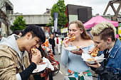 Young friends enjoying East End street food for lunch