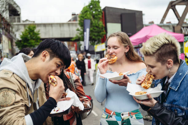 Jovens amigos desfrutando de comida de rua de East End para o almoço - foto de acervo