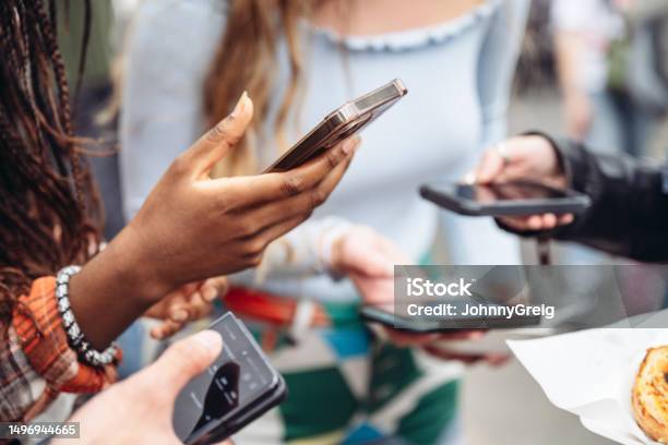 Gen Z Londoners Holding Smart Phones Using Social Media Stock Photo - Download Image Now