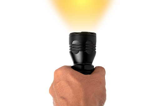 Black LED flashlight in male hand isolated on white background