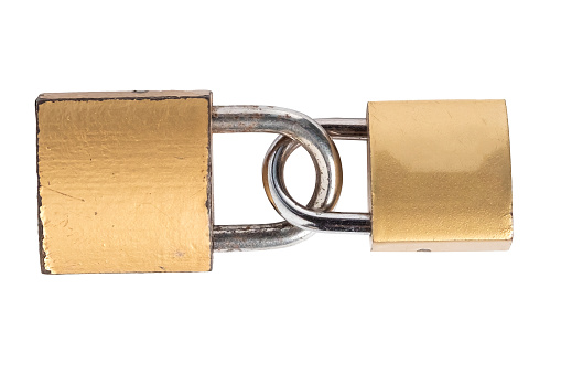 Two padlocks connected together on a white background. Macro shots