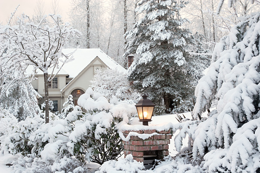 Driveway light and house on a snowy morning