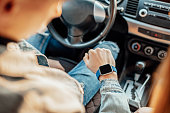 smart watch on the hand of car driver, close up. transport, business trip, technology, time and people concept