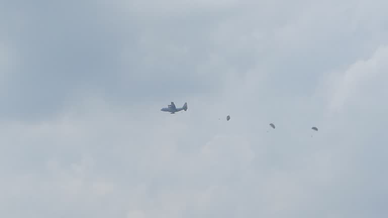 Paratroopers jumping of plane in during a military training exercise.