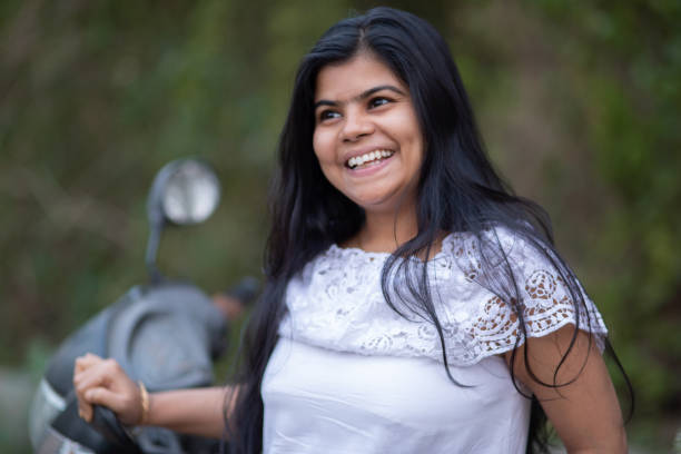 An Indian beautiful young girl with scooter smiling and having fun