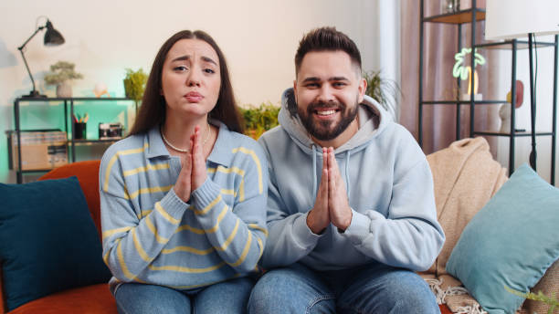 young family marriage couple praying sincerely with folded arms asking god for help, begging apology - pleading men women reconciliation imagens e fotografias de stock