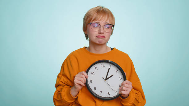 kobieta w okularach z niepokojem sprawdza czas na zegarze, spóźnia się do pracy, jest spóźniona, termin - checking the time time clock women zdjęcia i obrazy z banku zdjęć