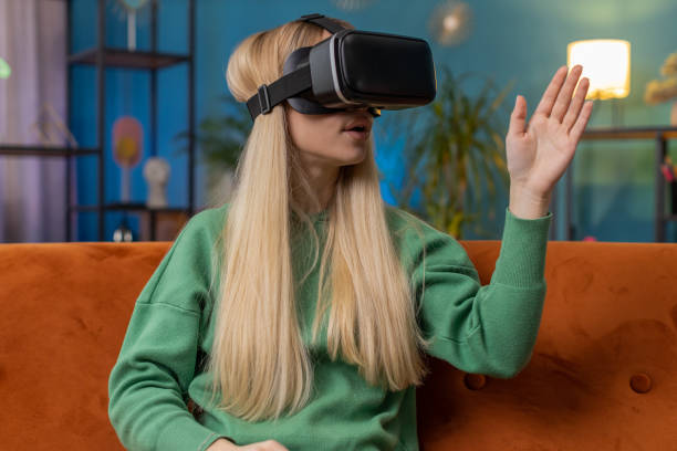 istock Excited woman virtual reality futuristic technology headset to play simulation 3D video game at home 1496950202