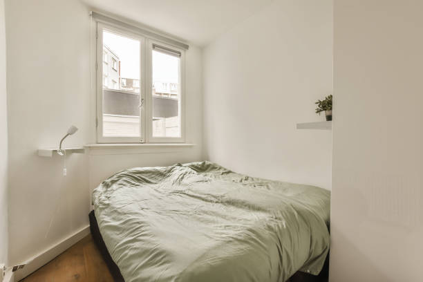 istock a bedroom with a bed and a window 1496950372
