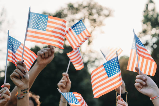 istock A group of people is waving small American flags at sunset 1496951713