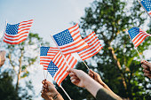 A group of people is waving small American flags at sunset