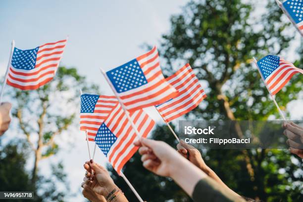 A Group Of People Is Waving Small American Flags At Sunset Stock Photo - Download Image Now