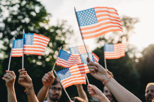istock A group of people is waving small American flags at sunset 1496951723