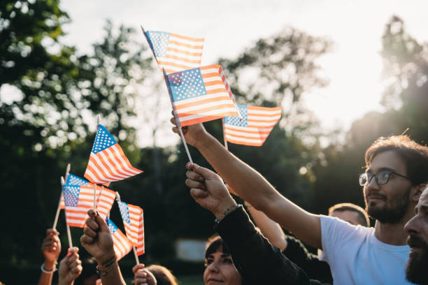 istock A group of people is waving small American flags at sunset 1496951730