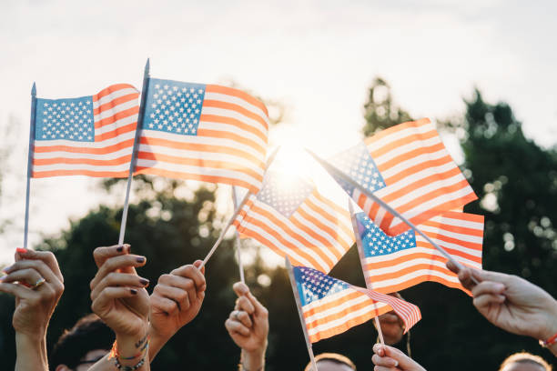istock A group of people is waving small American flags at sunset 1496951731
