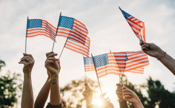 istock A group of people is waving small American flags at sunset 1496951734