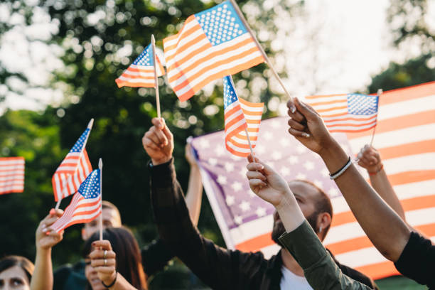 istock A group of people is waving small American flags at sunset 1496951745