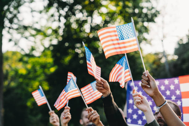 istock A group of people is waving small American flags at sunset 1496951756