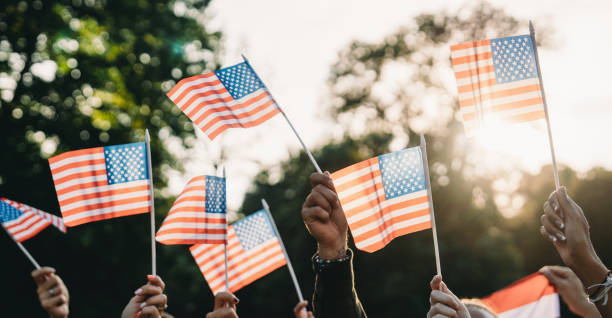 istock A group of people is waving small American flags at sunset 1496951768