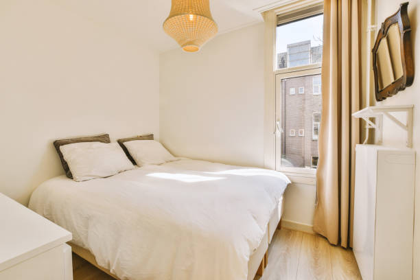 istock a small bedroom with a bed and a window 1496951941